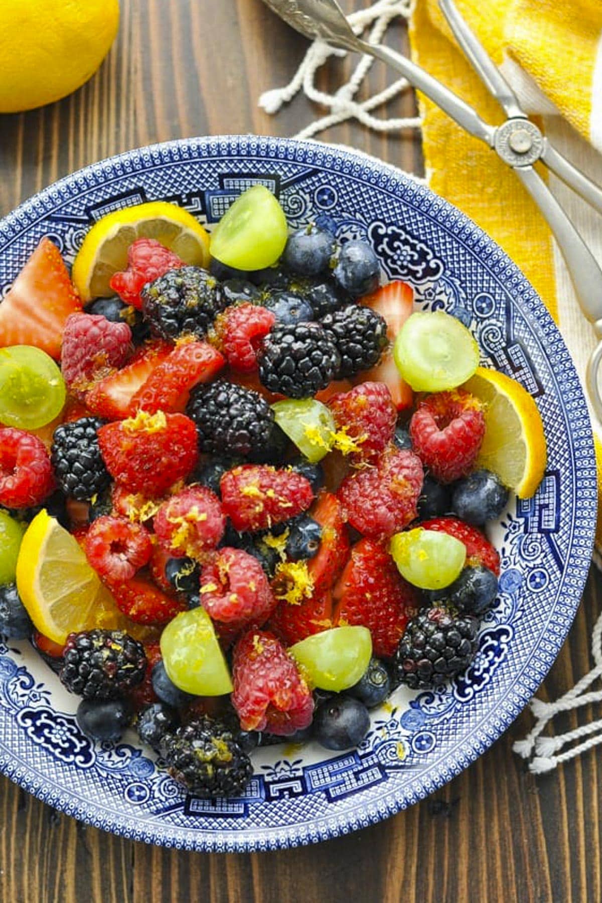 Close overhead image of a bowl of fresh berries and grapes tossed with a honey lemon fruit salad dressing.