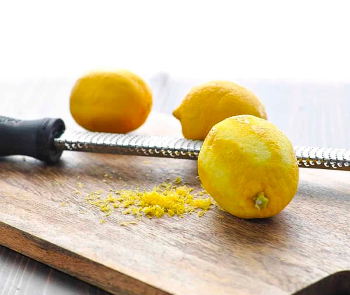 Zesting lemons on a cutting board.