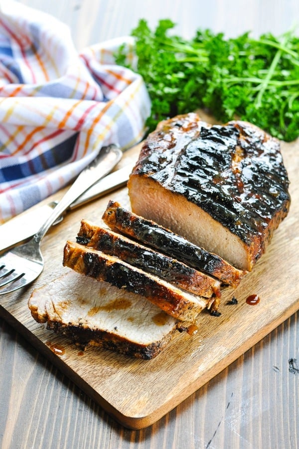 Honey glazed grilled pork loin sliced on a cutting board