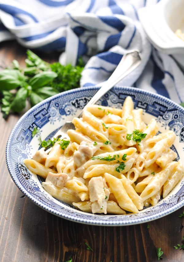 Close up front shot of blue and white bowl full of parmesan pasta with chicken