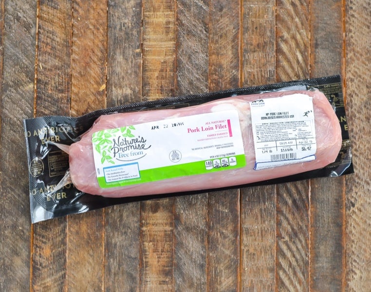 Pork loin filet in packaging on a wood surface