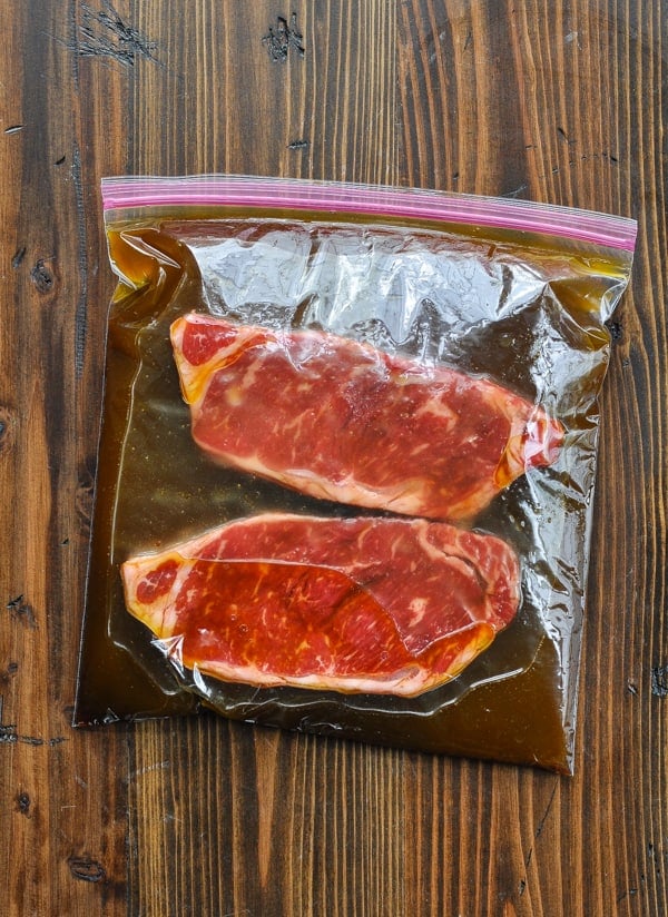 Marinating new york strip steaks in a plastic bag with the best steak marinade recipe