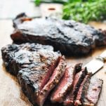 Sliced New York Strip Steaks on a cutting board after using a steak marinade and grilling