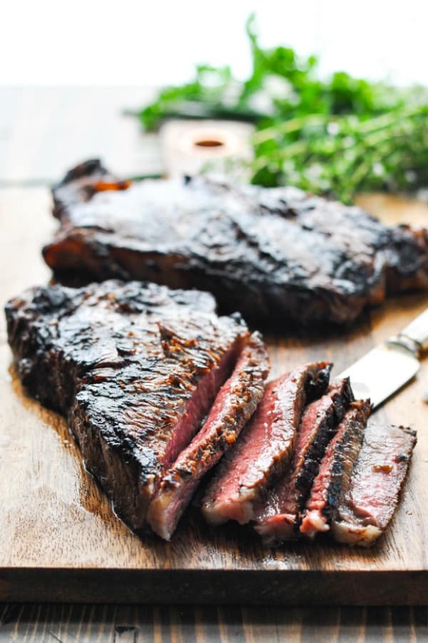 Sliced New York Strip Steaks on a cutting board after using a steak marinade and grilling