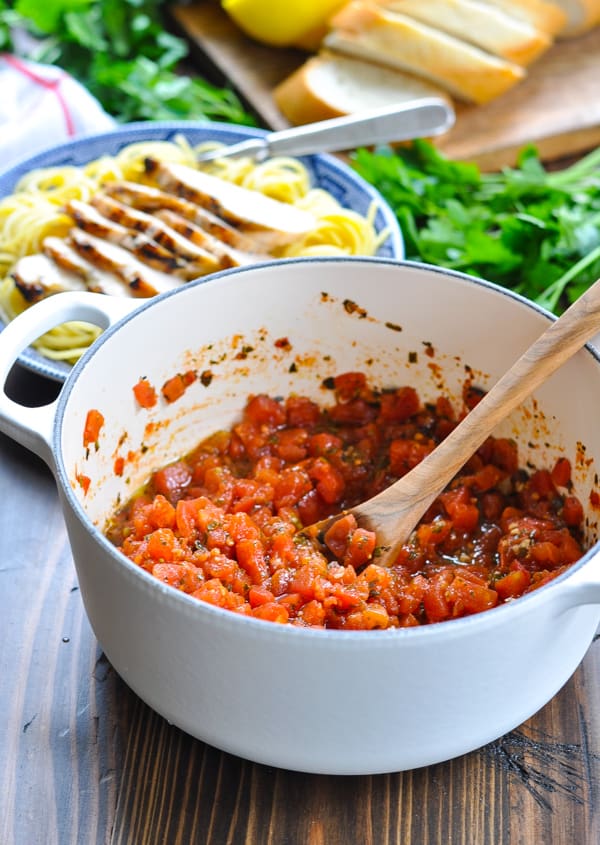Stirring tomato pesto sauce with a wooden spoon