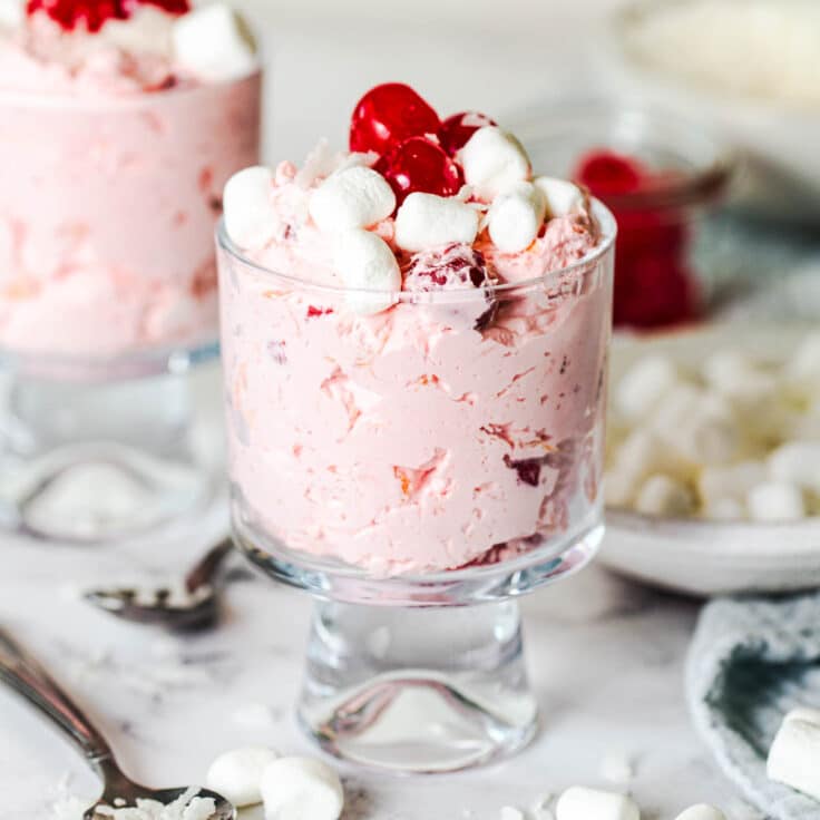 Square side shot of two glass bowls with cherry fluff salad.