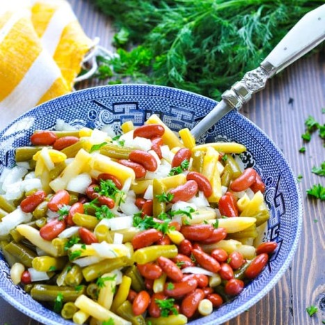 Classic three bean salad in a blue and white serving bowl