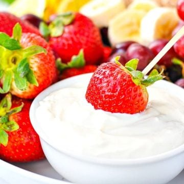 Dipping a strawberry into a fresh fruit dip