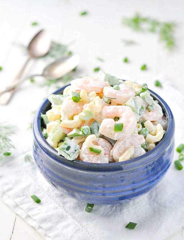 Front shot of Aunt Bee's Shrimp and Pasta Salad in a blue serving bowl garnished with sliced green onions