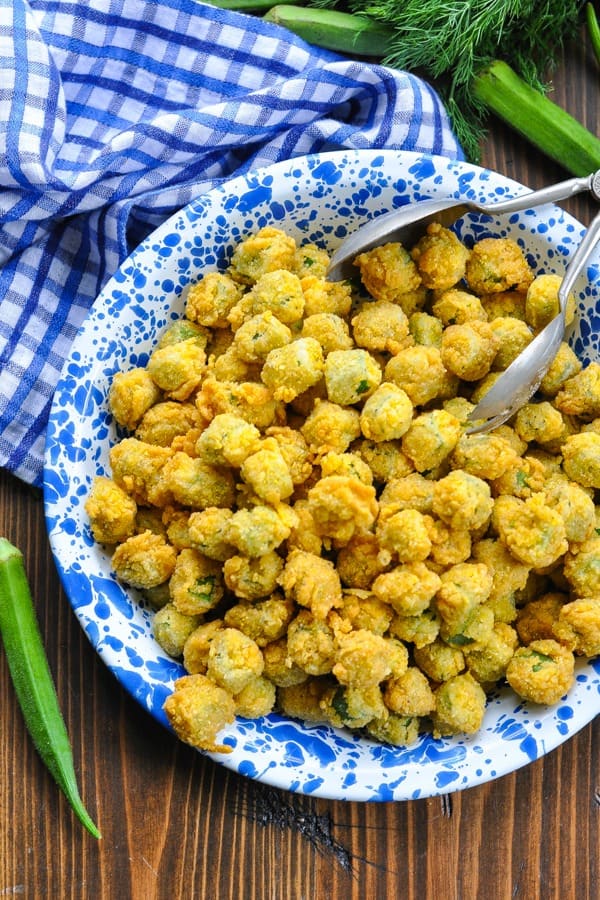 Close up overhead shot of crispy fried okra in a blue and white serving dish