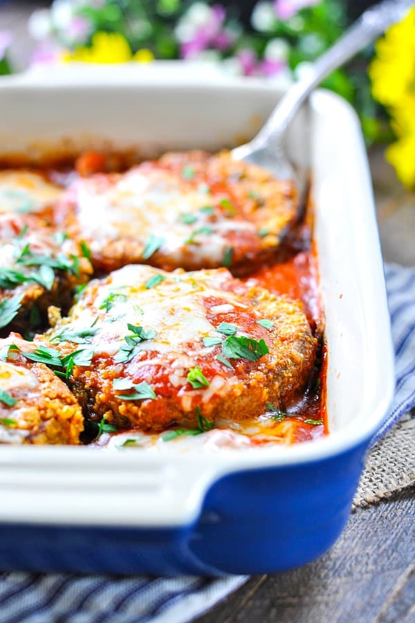 Close up of baked eggplant parm in blue baking dish