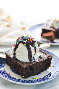 Vanilla ice cream and chocolate syrup on top of zucchini cake