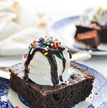 Vanilla ice cream and chocolate syrup on top of zucchini cake