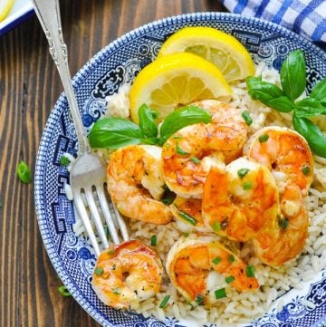 Marinated grilled shrimp served over rice in a blue and white bowl