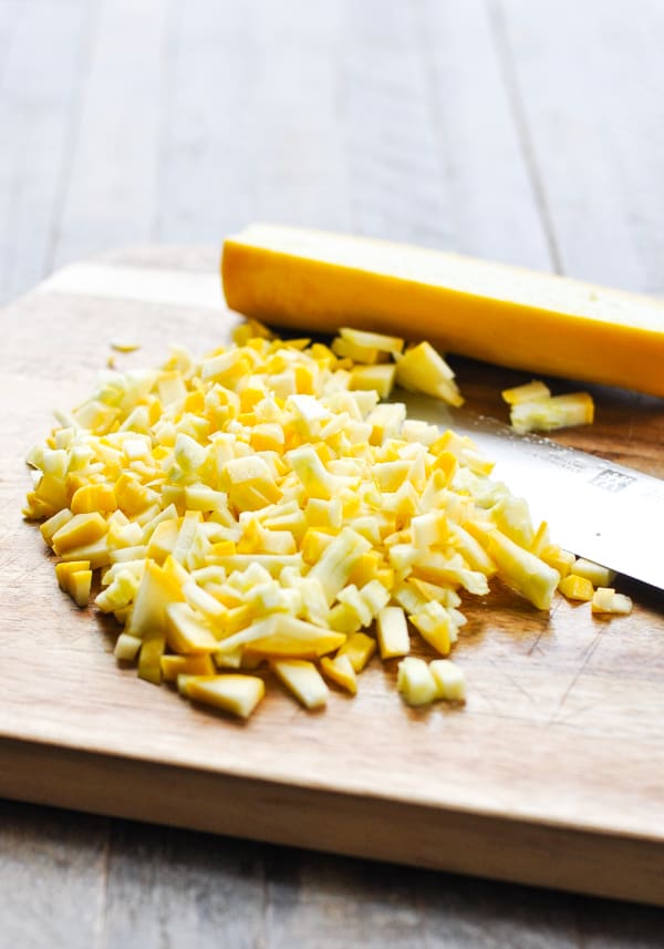Finely diced yellow summer squash on a cutting board
