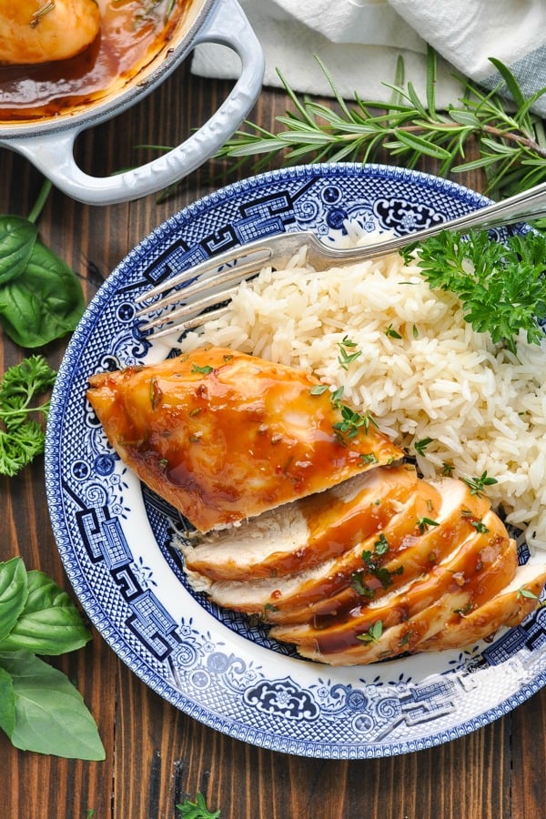 Close up shot of baked chicken breast recipe on a plate with rice