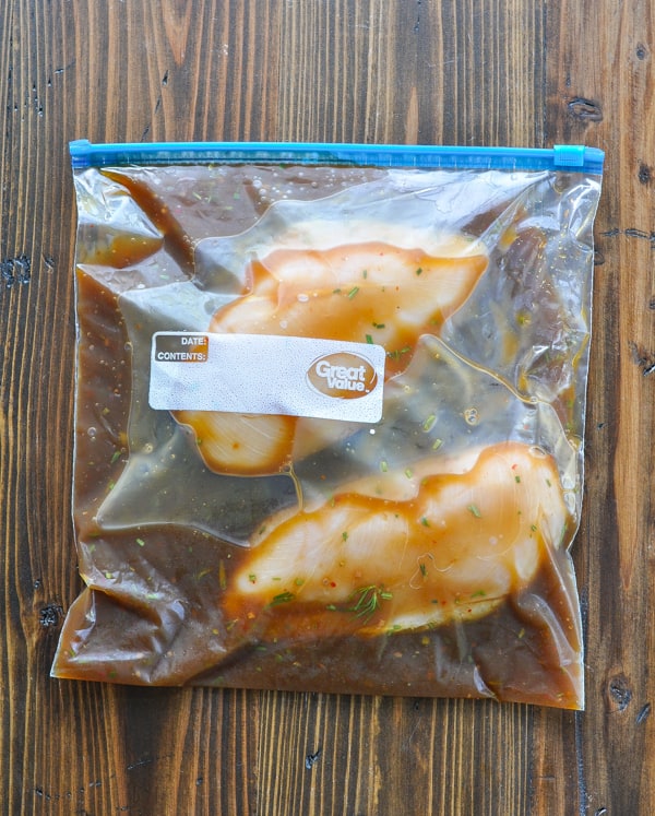 Chicken breasts marinating in a large Ziploc bag