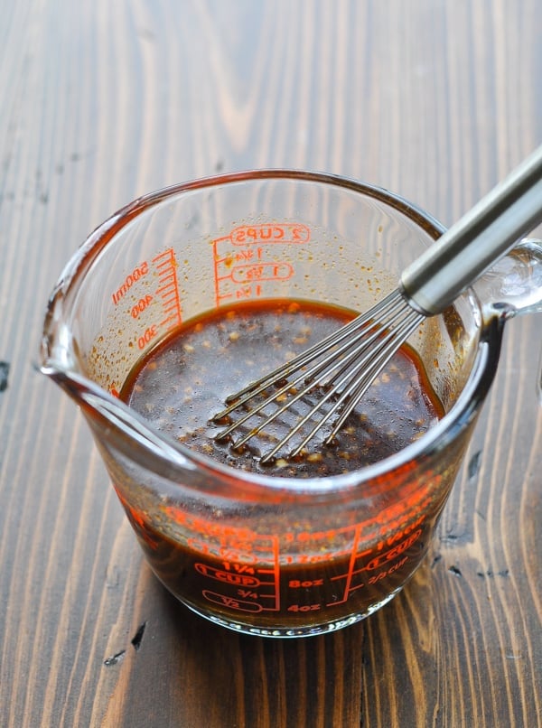 Honey garlic chicken marinade in measuring cup with whisk