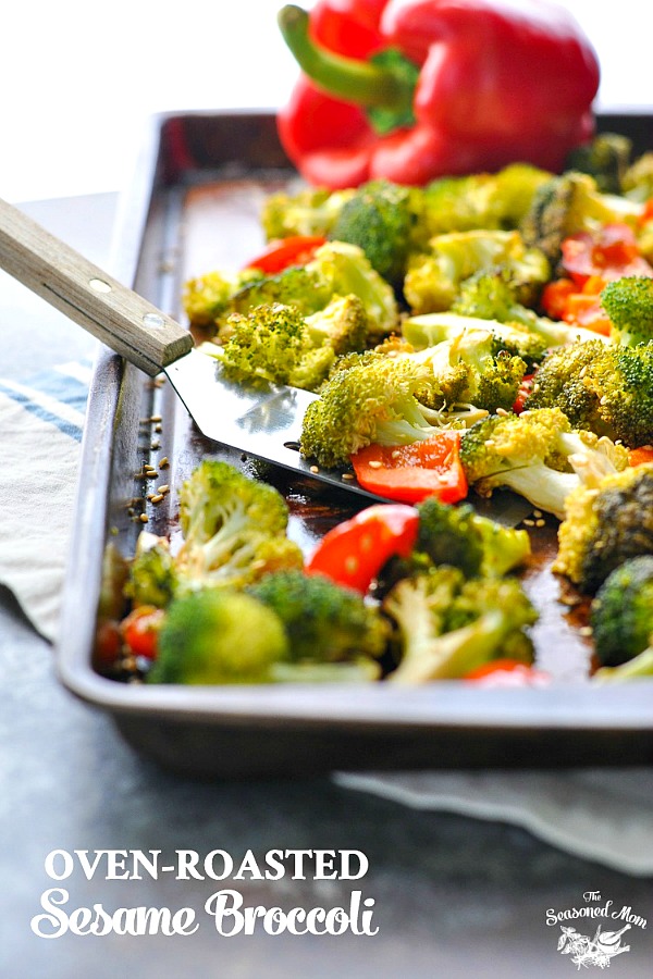 A close up of oven roasted broccoli on a baking tray