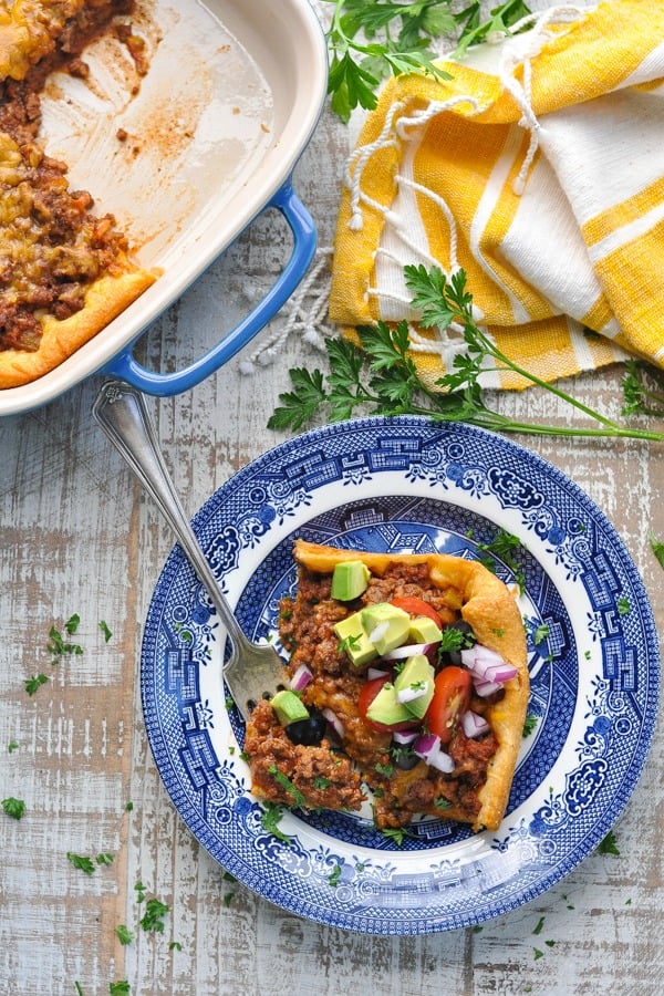 Close overhead shot of a slice of taco crescent casserole on a plate with toppings