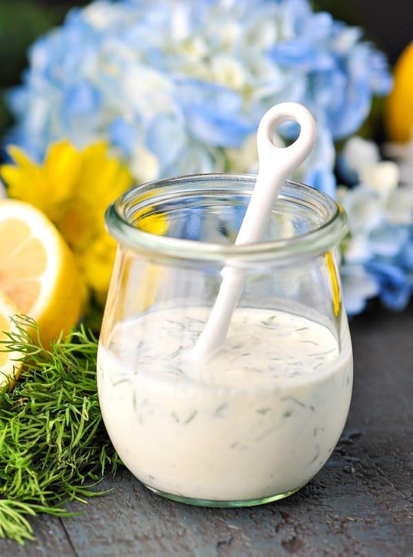 Jar of creamy buttermilk dressing with a white spoon in the jar