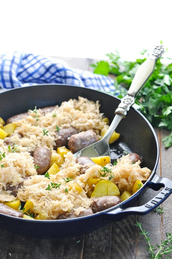 German sausage in a skillet with a serving spoon