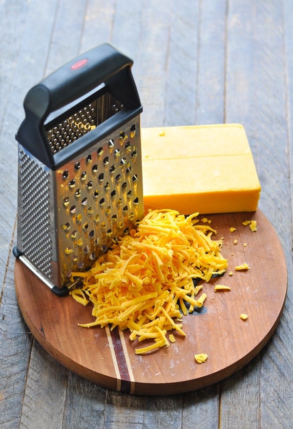 Grated cheddar cheese on a cutting board
