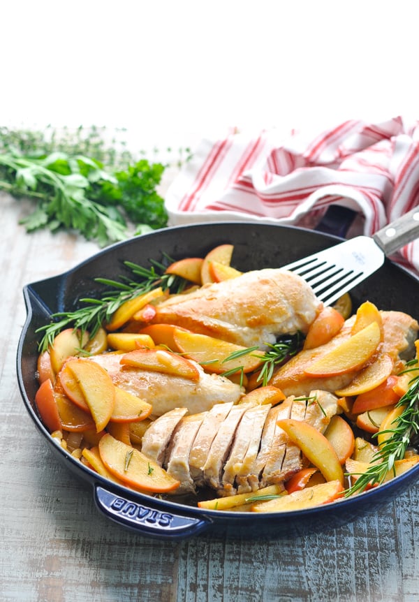 Front shot of a skillet chicken recipe with apples and onions