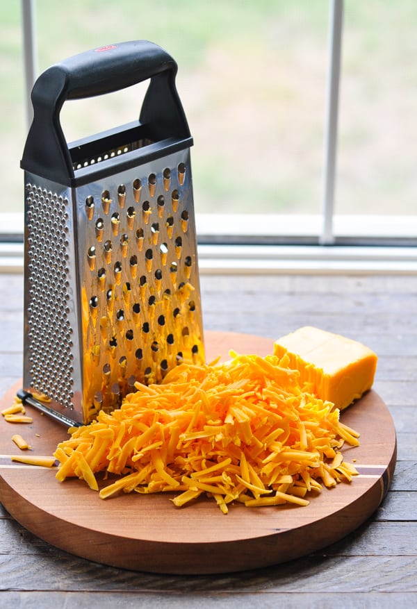 Grated cheddar cheese on cutting board