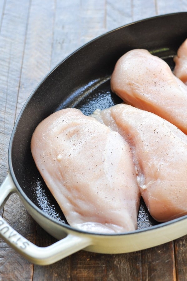 Raw chicken breasts in a baking dish with salt and pepper
