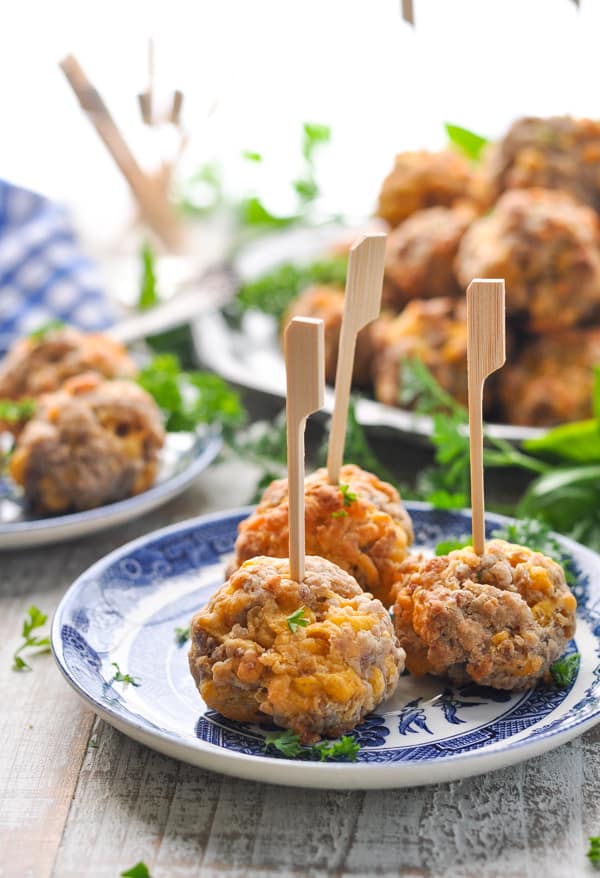 Three sausage balls with toothpicks on an appetizer plate