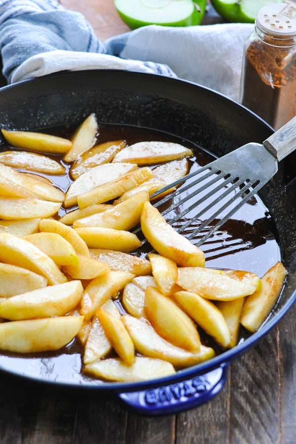 Close front shot of fried apple slices in a skillet