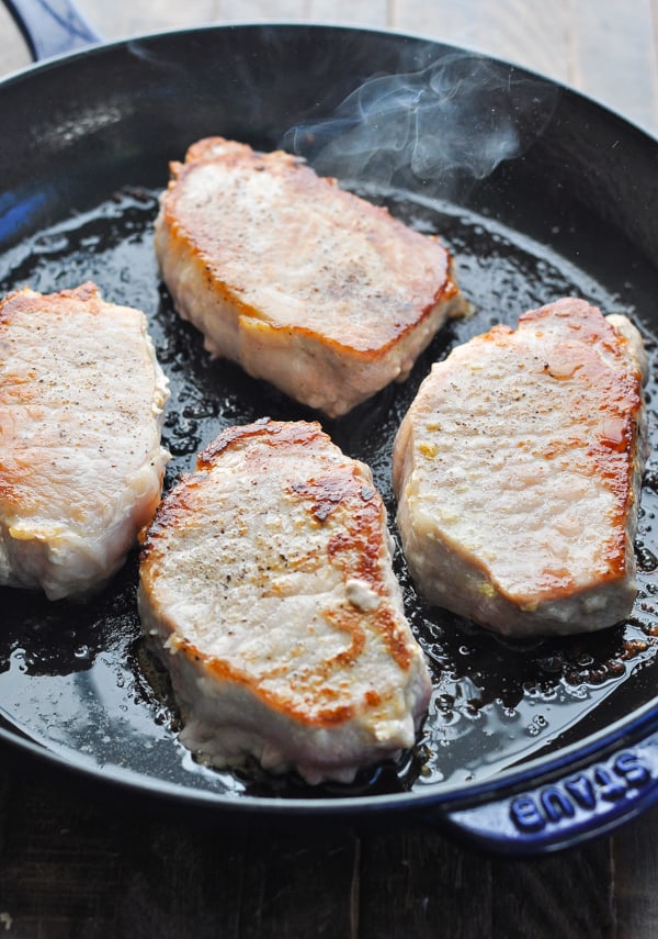Browned boneless pork chops in cast iron skillet