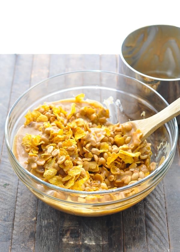 Mixing together no bake cornflake cookies in a large glass bowl
