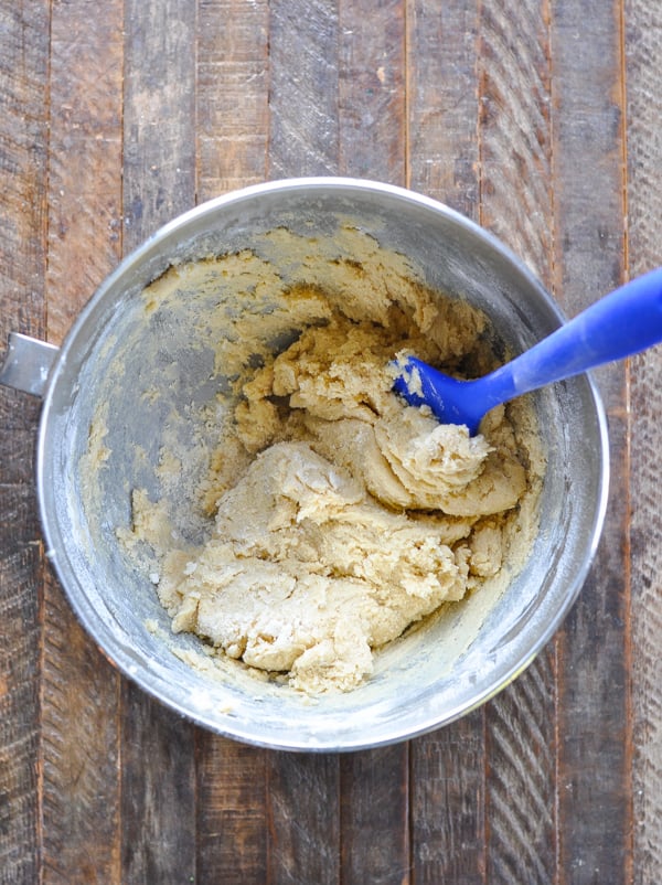 Cookie dough with blue spatula in a large mixing bowl