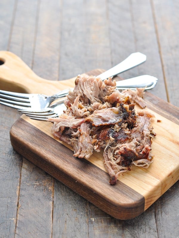 Pulled pork on a cutting board with two forks