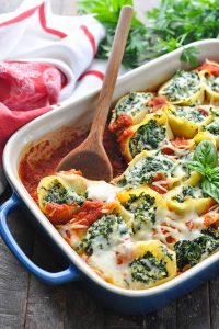 Close up image of spinach stuffed shells in a baking dish
