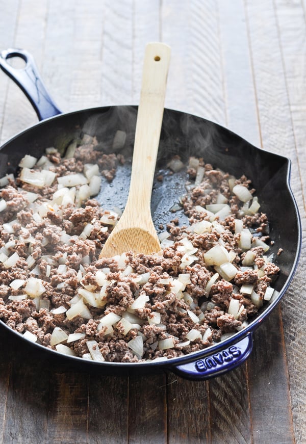 Ground beef and onion in a cast iron skillet