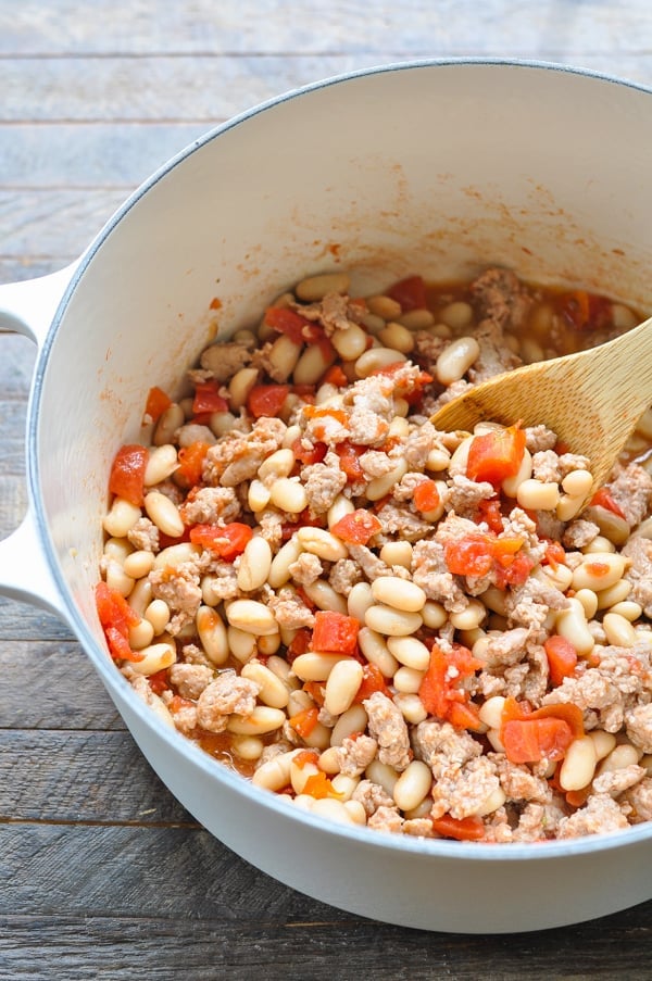 Sausage white beans and diced tomatoes in a soup pot