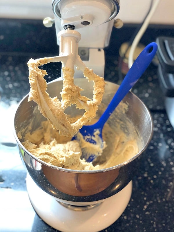 Blonde brownies batter in a stand mixer with blue spatula