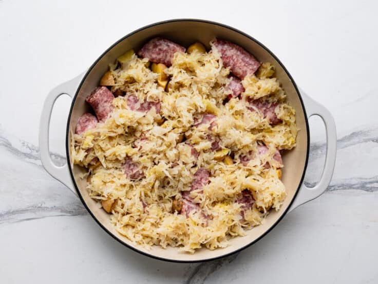 Arranging sauerkraut with the brats and potatoes.