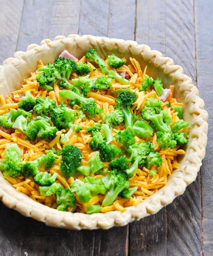 Process shot showing how to make a ham and broccoli quiche.