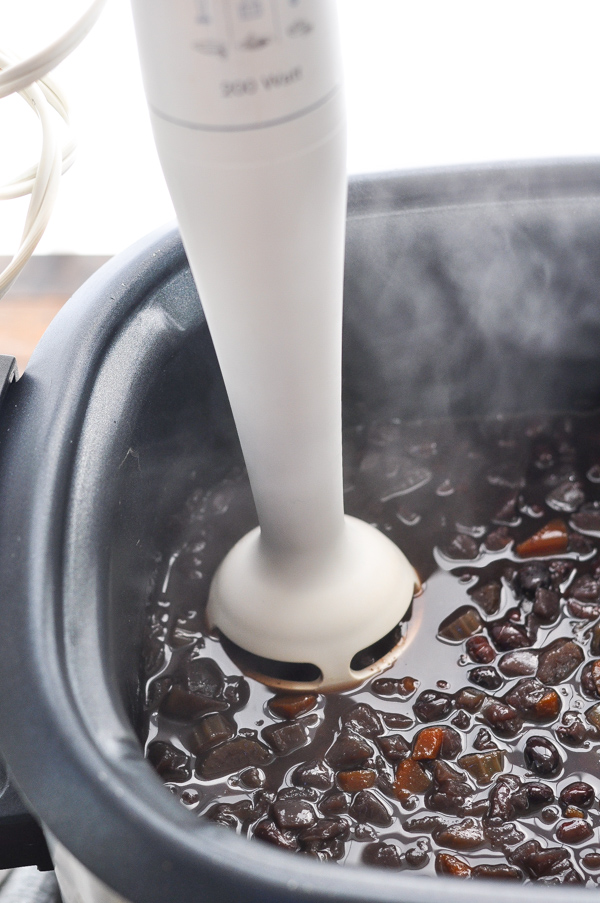 Using an immersion blender to puree black bean soup