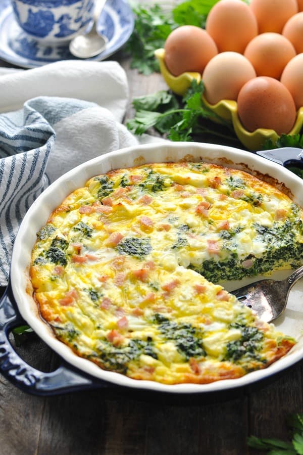 Front shot of a crustless quiche in a dish with a blue and white towel