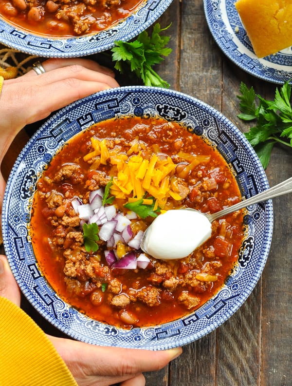 Hands holding a bowl of turkey chili