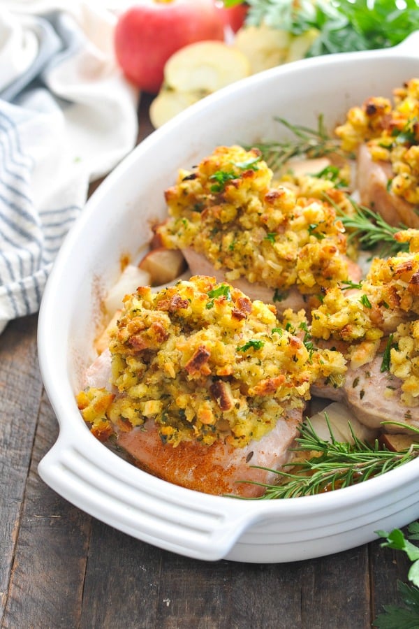 Baked boneless pork chops with stuffing and apples in a white baking dish