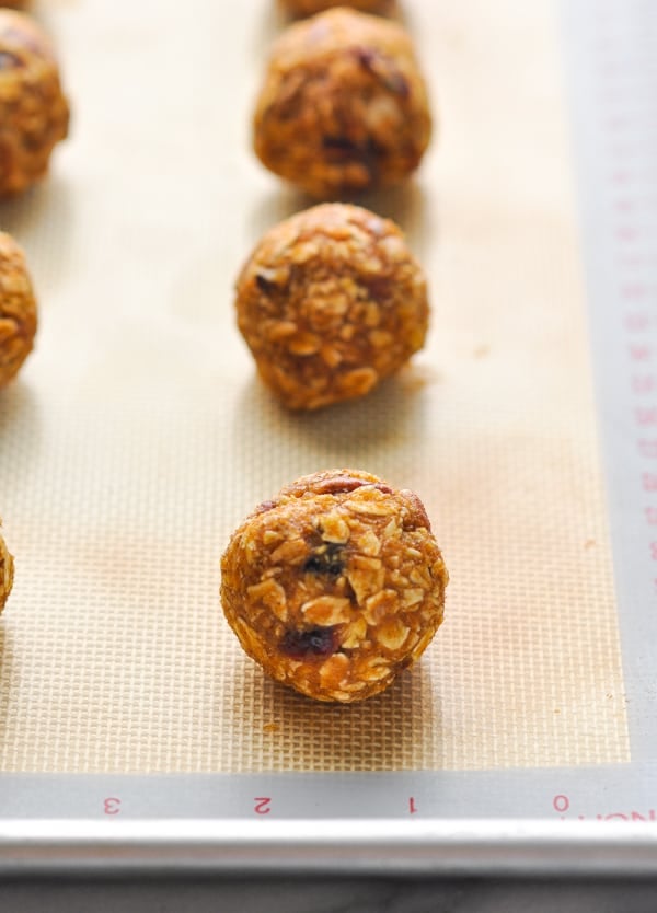 Energy balls lined up on a baking sheet to chill