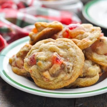 Square close up side shot of a plate of fruitcake cookies.
