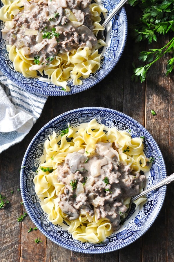 Close overhead shot of ground beef stroganoff in a bowl with egg noodles and fresh parsley