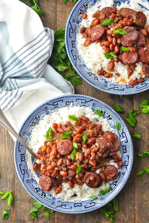Long overhead shot of two bowls of Instant Pot Red Beans and Rice on a wooden table